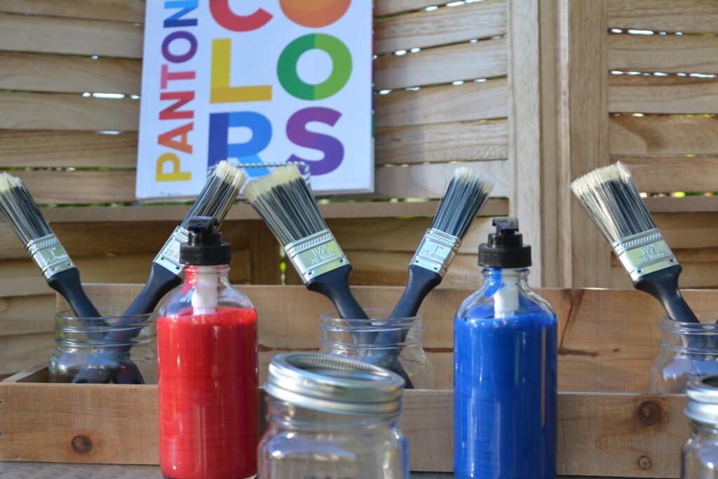 Photo of atelier with different sized paintbrushes and pantone color book for inspiration