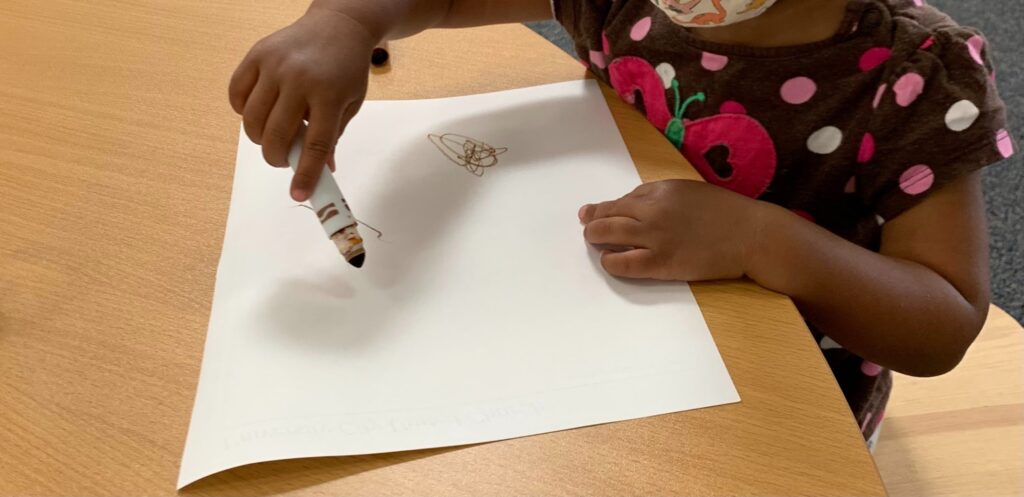 Child making marks to express her ideas