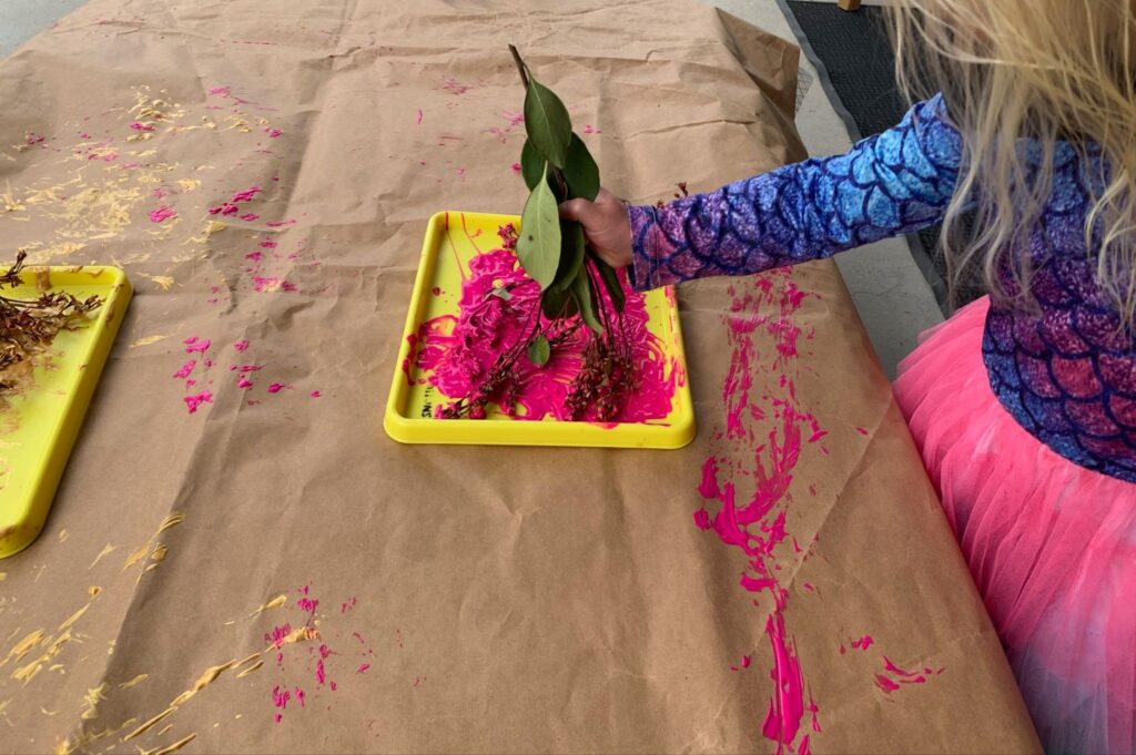 children using flowers and nature as paintbrushes